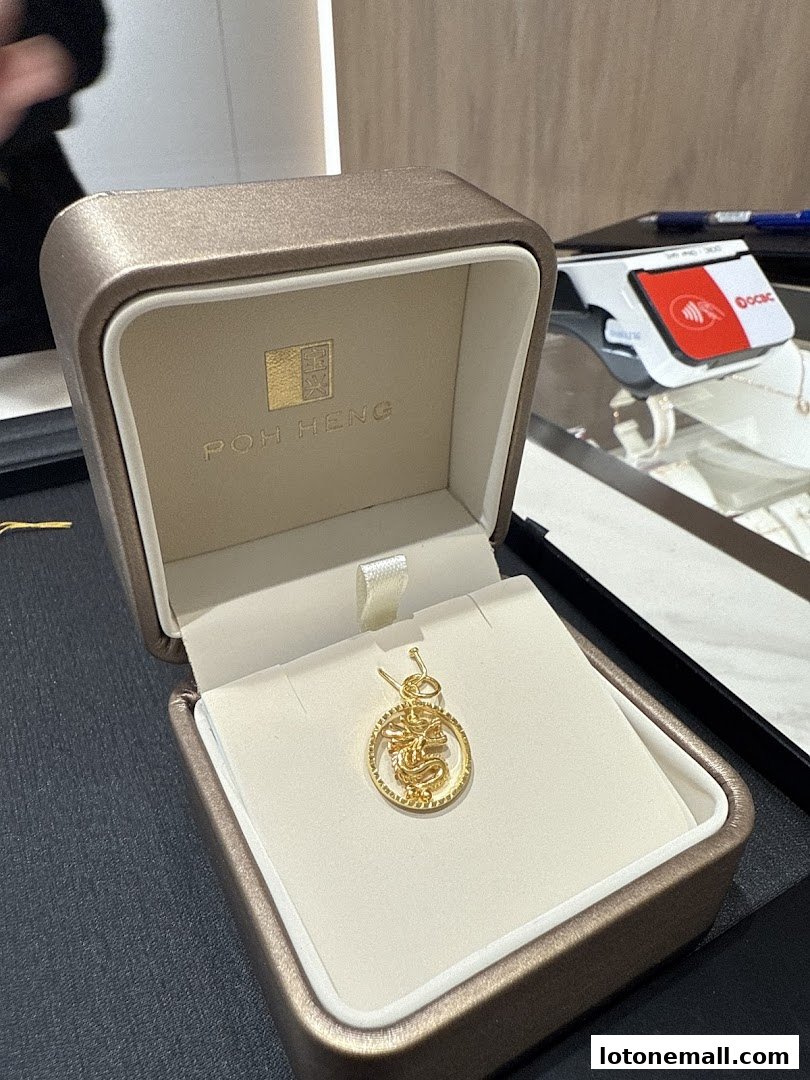 A gold dragon pendant is displayed in an open jewelry box.
