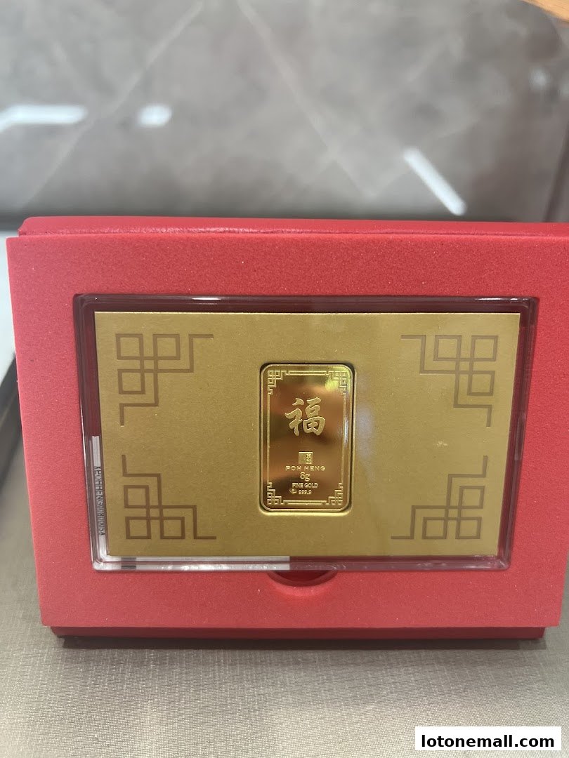 A gold bar with Chinese characters for fortune in a red presentation box.