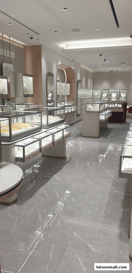 Interior view of a modern jewelry store with display cases filled with necklaces and bracelets.