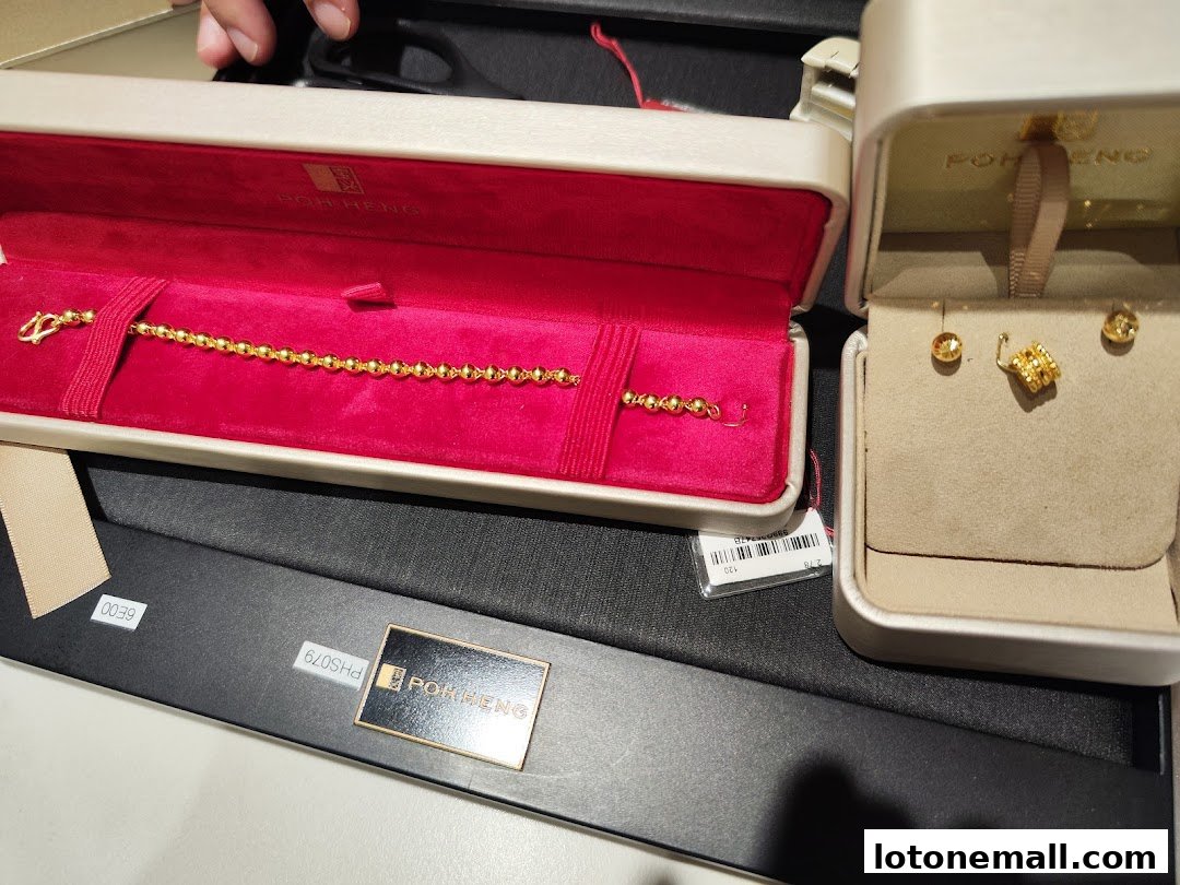 A gold bracelet and earrings displayed in elegant jewelry boxes.