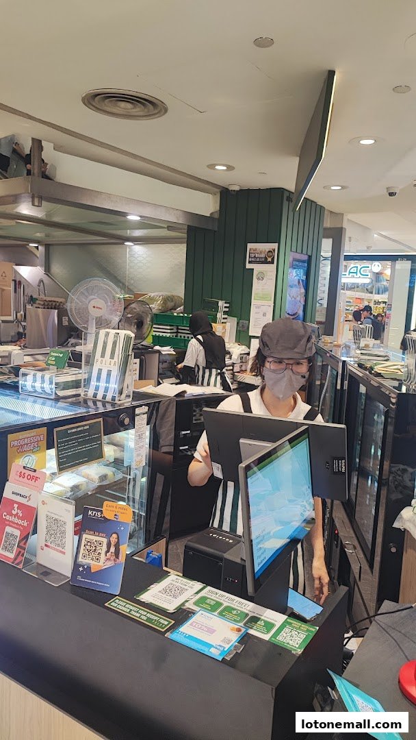 Staff members at the counter of Polar Puffs & Cakes, with promotional signs and payment QR codes visible.