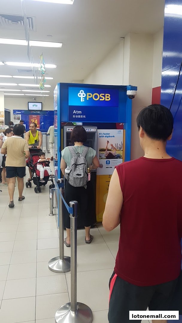 People queuing at a POSB ATM machine inside a store.