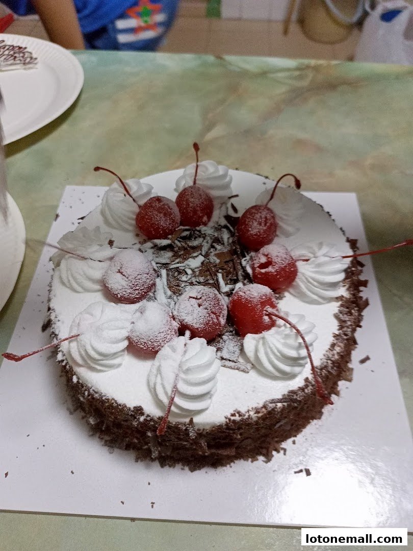 A delicious Black Forest cake topped with whipped cream and cherries.