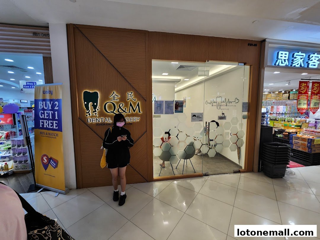 A person stands outside the Q&M Dental Surgery shop in a mall.