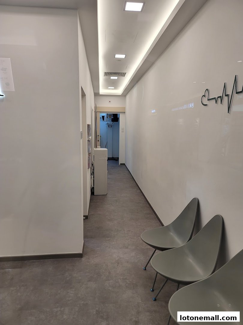 A clean and modern waiting area with chairs and a hallway leading to dental treatment rooms.
