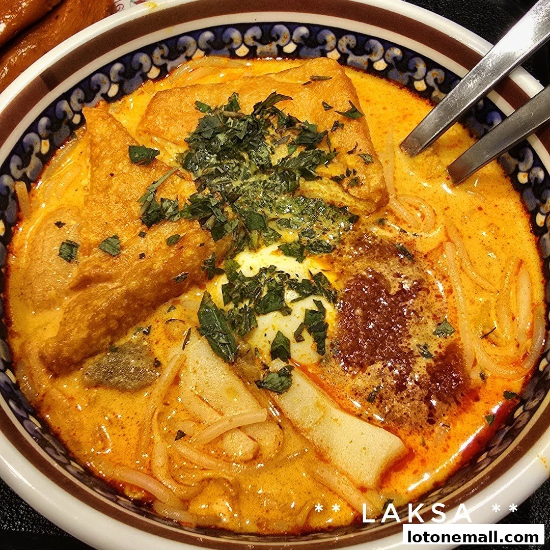 A close-up shot of a delicious bowl of Laksa with various toppings and a rich, creamy broth.
