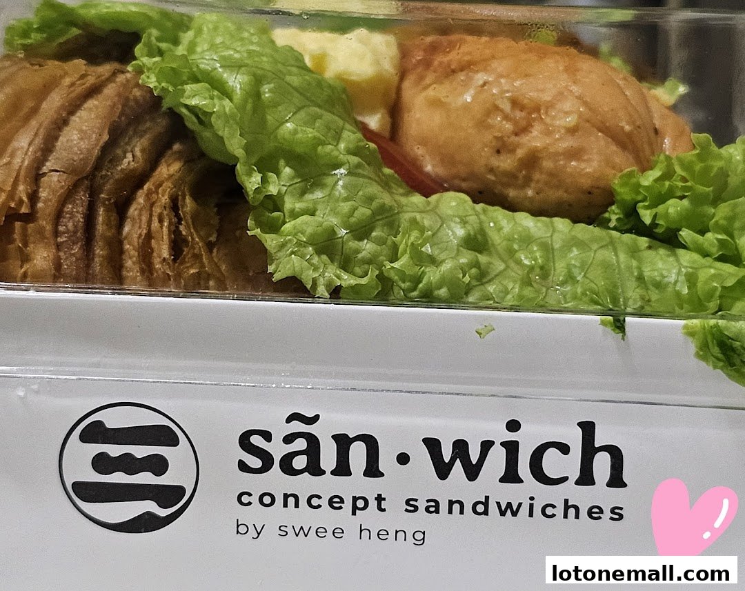 A close-up of a sandwich with lettuce, tomato, and a pastry.