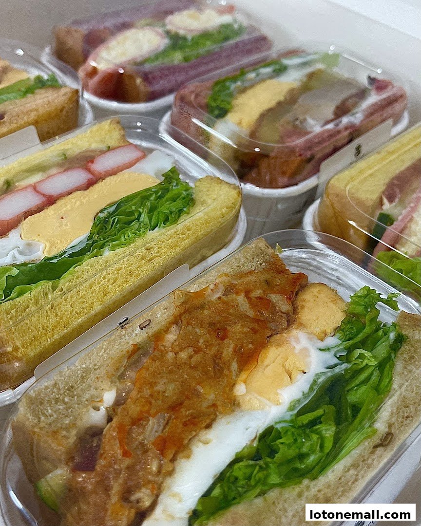 A close-up view of several delicious and fresh sandwiches in clear plastic packaging.
