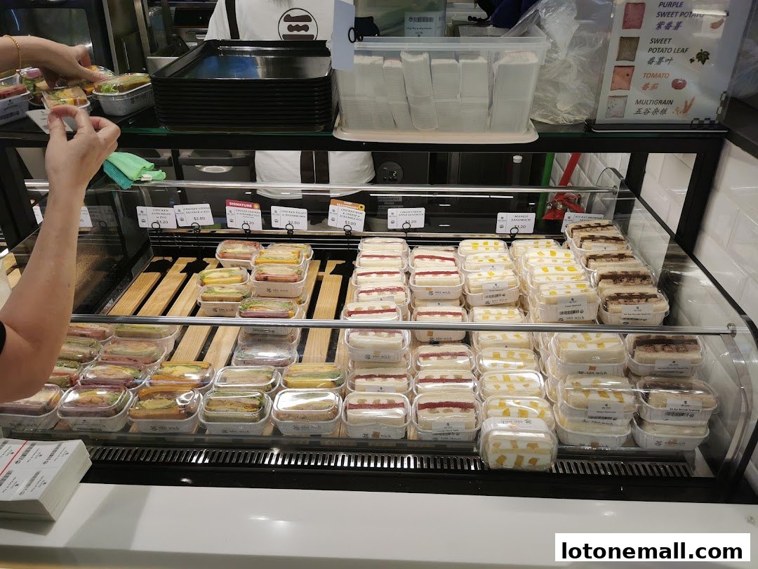 A display case filled with various pre-packaged sandwiches and snacks at San.wich by Swee Heng.