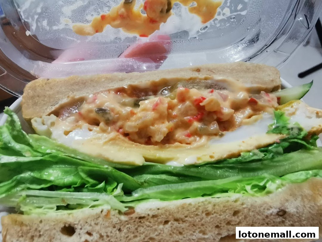 A close-up view of a delicious sandwich with fresh lettuce, egg, and a creamy filling.