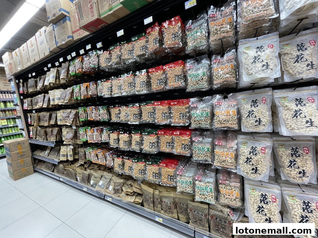 Shelves stocked with various packaged snacks, primarily peanuts, in a supermarket.
