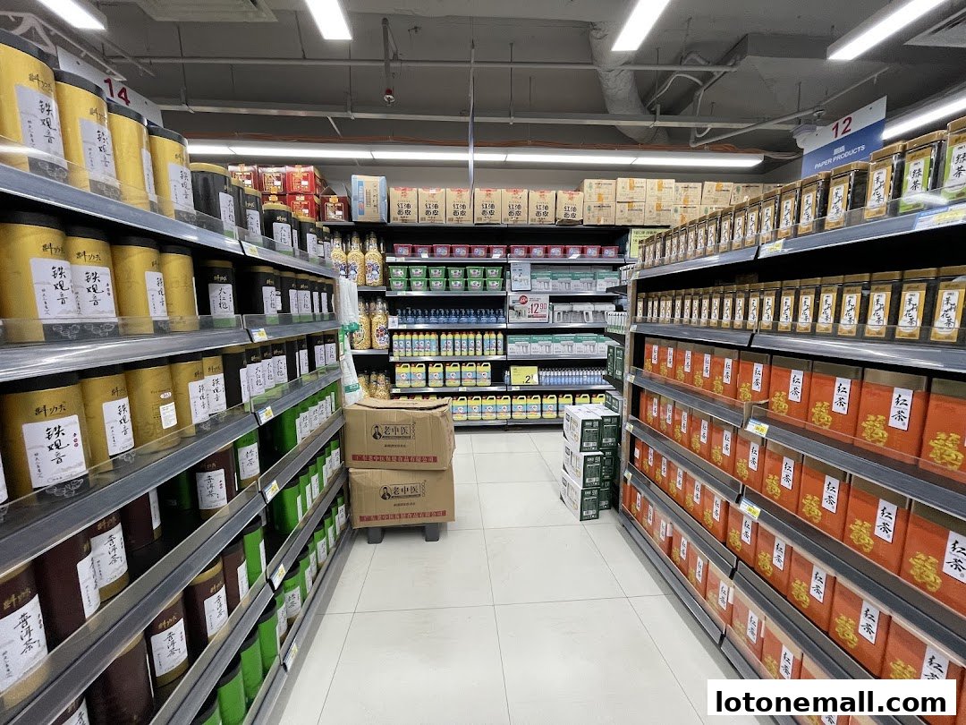 Aisle in a supermarket with shelves stocked with various tea products and other goods.