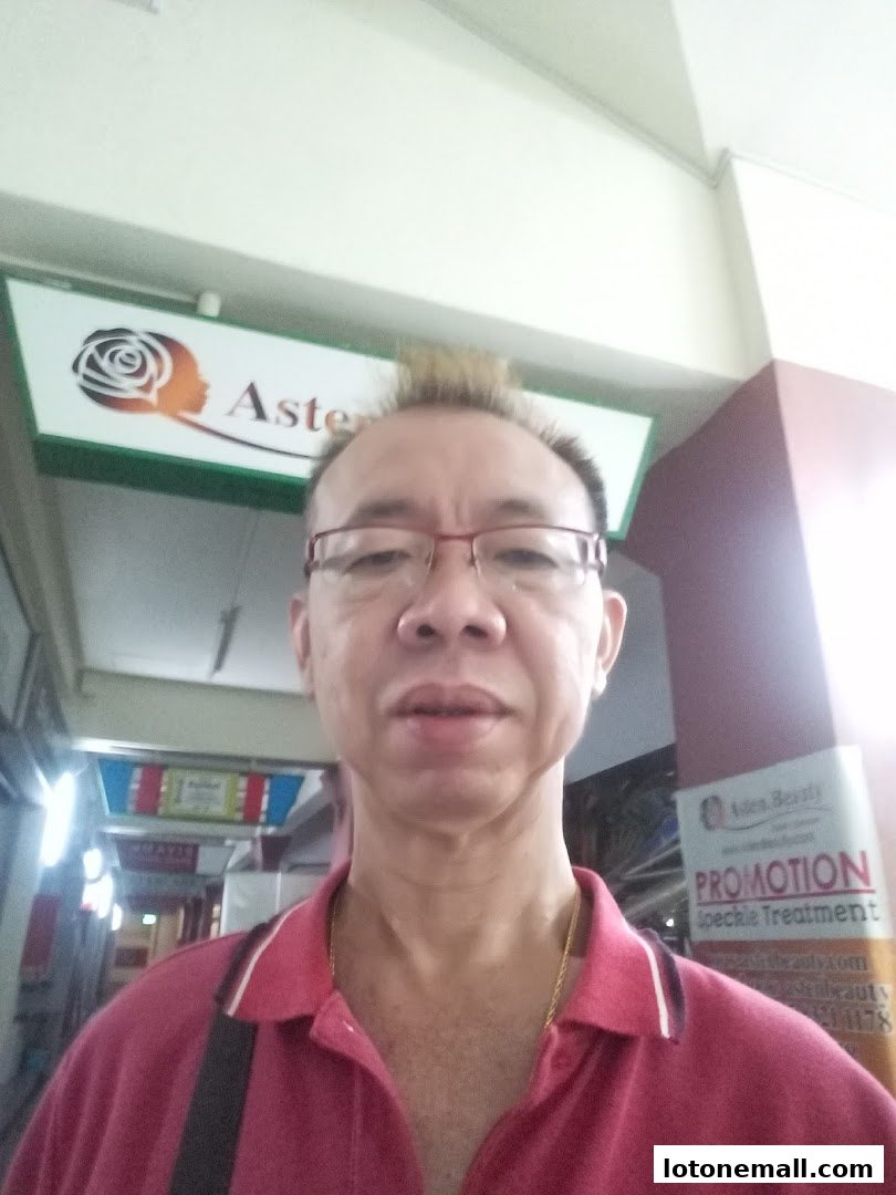 A man stands in front of a shop with a sign that says 'Aster'.