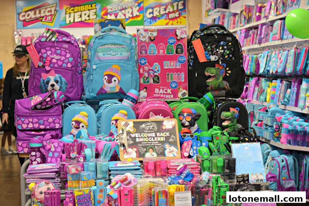 A vibrant display of Smiggle backpacks, lunchboxes, and stationery with a 'Back to School' theme.