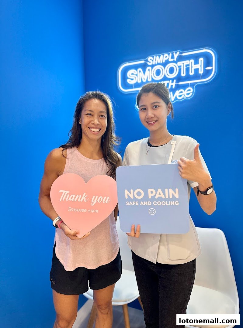Two smiling women holding signs at Smoovee Skin Korean Hair Removal.