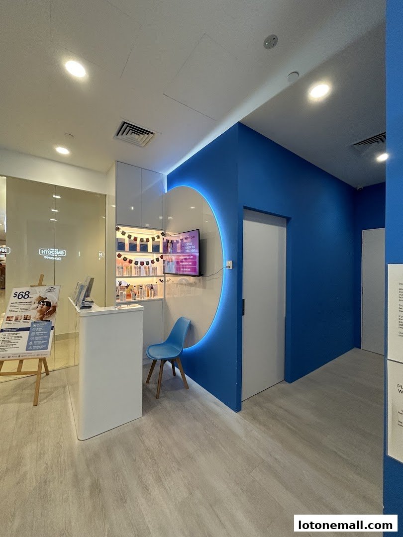 Interior of a modern hair removal salon with a reception desk and blue accent wall.