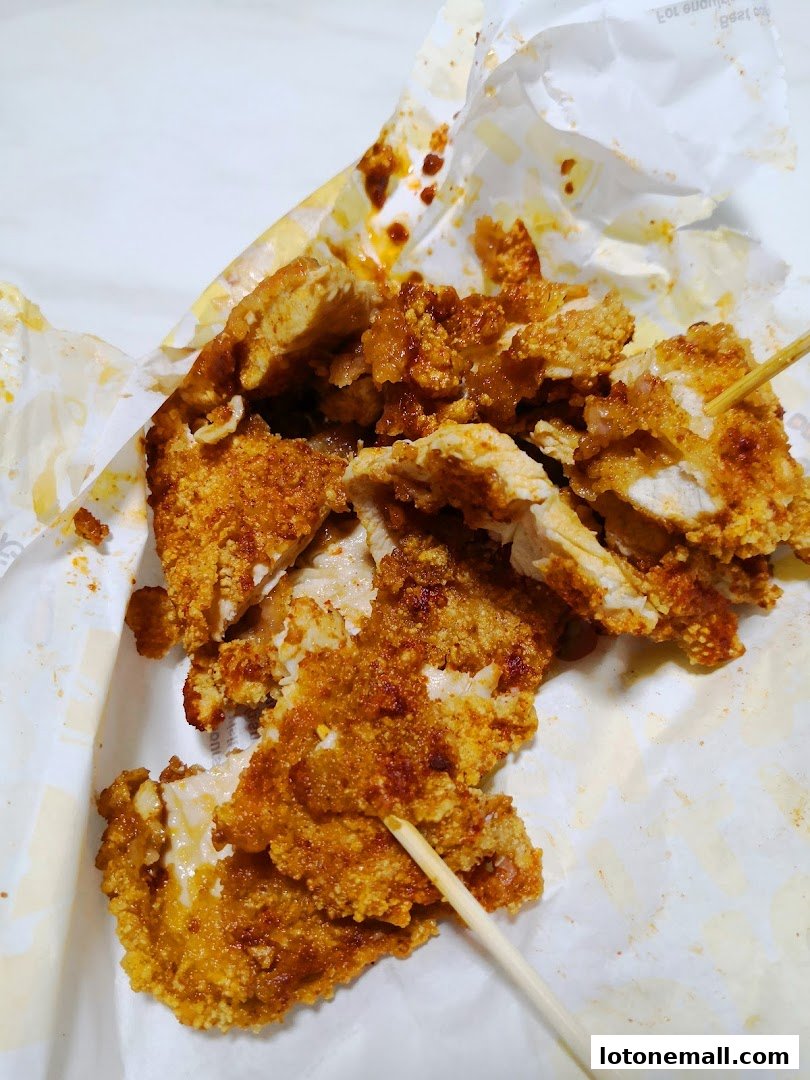Crispy fried chicken pieces seasoned with spices, served on paper.