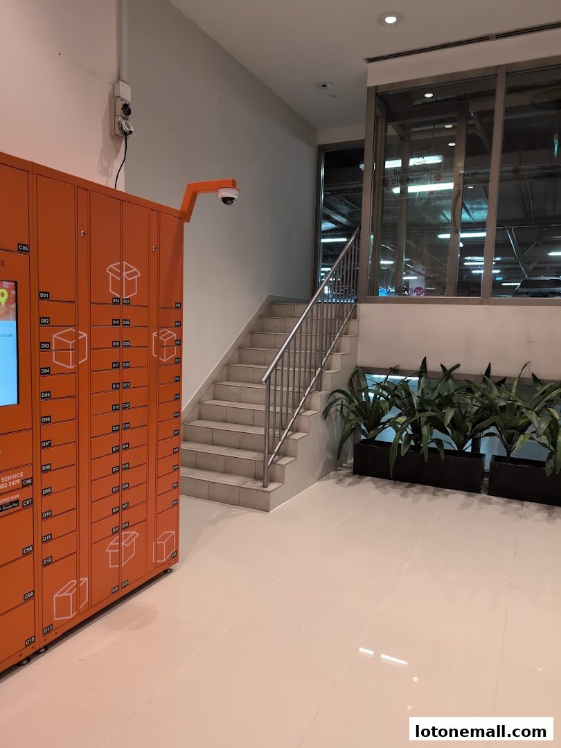 Orange SPX Express lockers are lined up next to a staircase and potted plants.