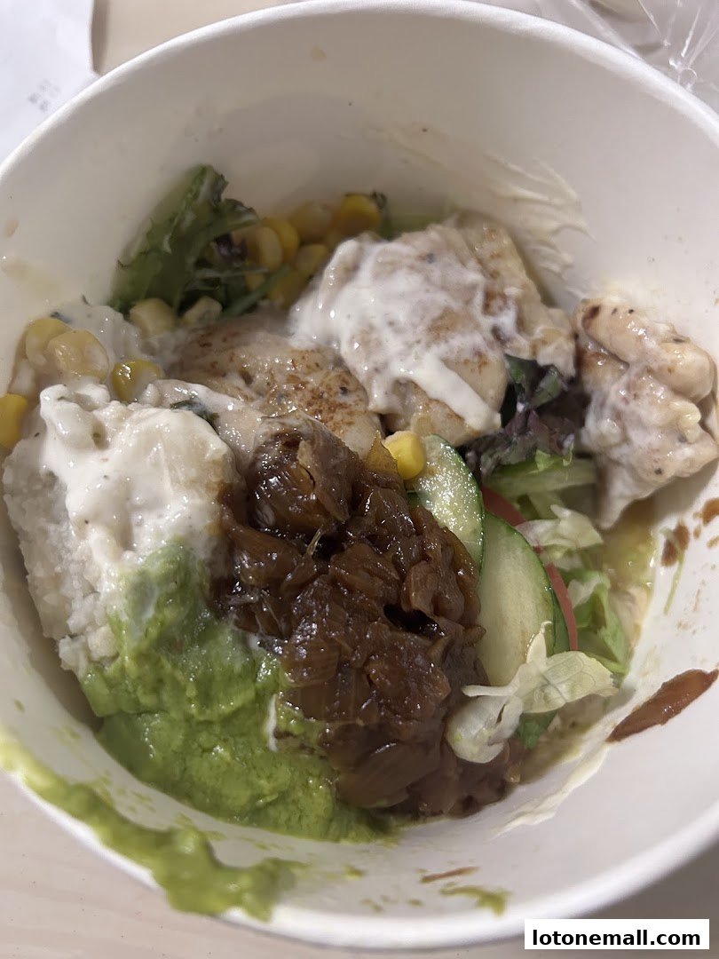 A close-up view of a Subway bowl with rice, chicken, avocado, corn, and other toppings.