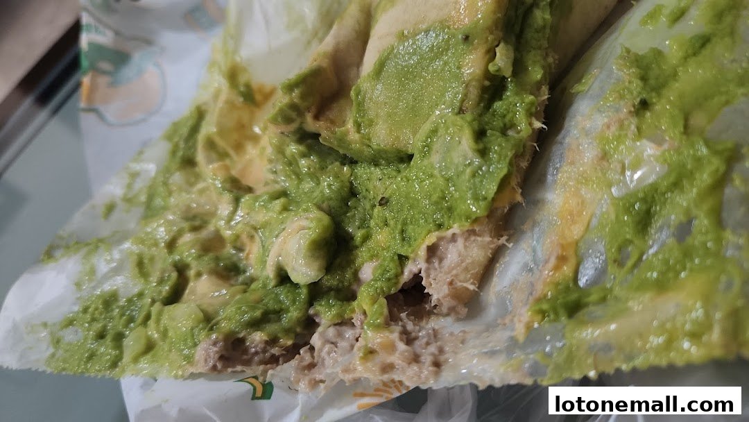 A close-up of a Subway sandwich with generous avocado and meat filling.