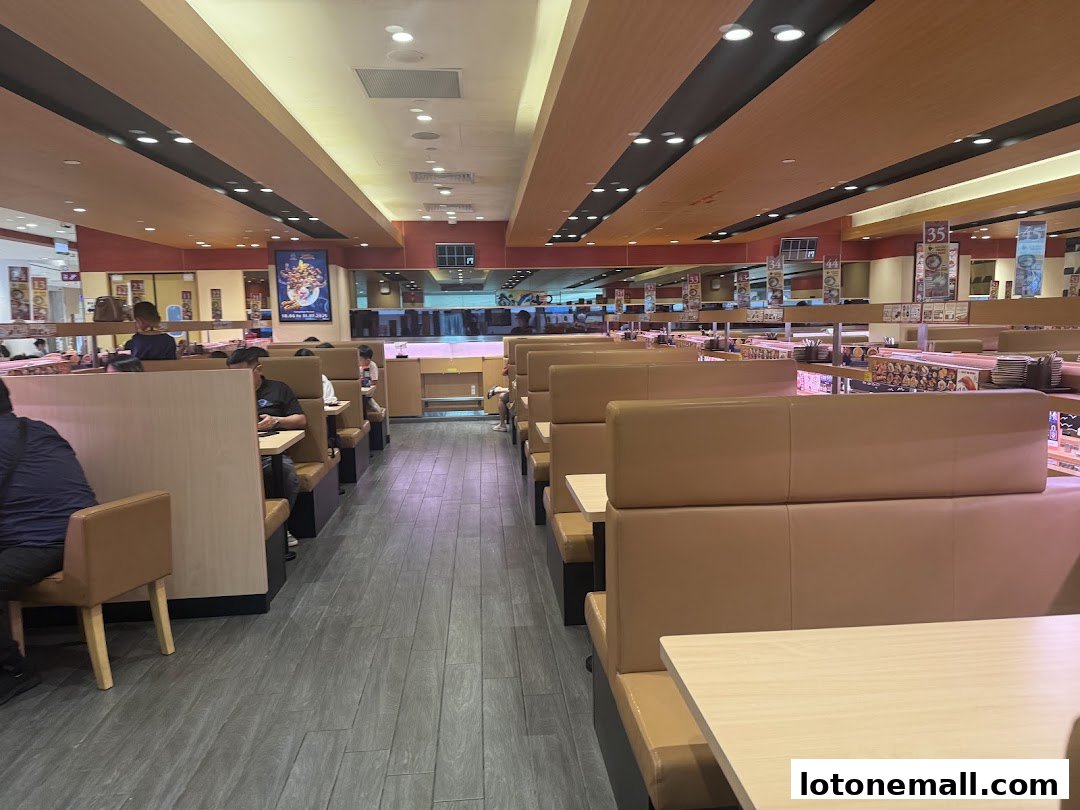 Interior view of a busy Sushiro restaurant with conveyor belts and seating.