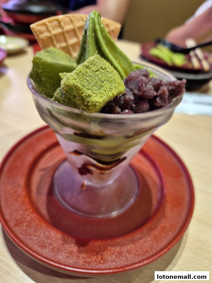 A matcha parfait with red bean paste, mochi, and a waffle cone.