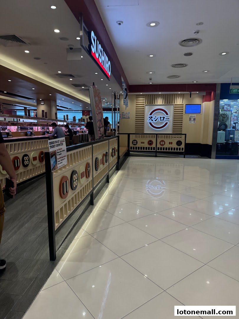 Interior view of Sushiro Lot One, a conveyor belt sushi restaurant with customers seated.