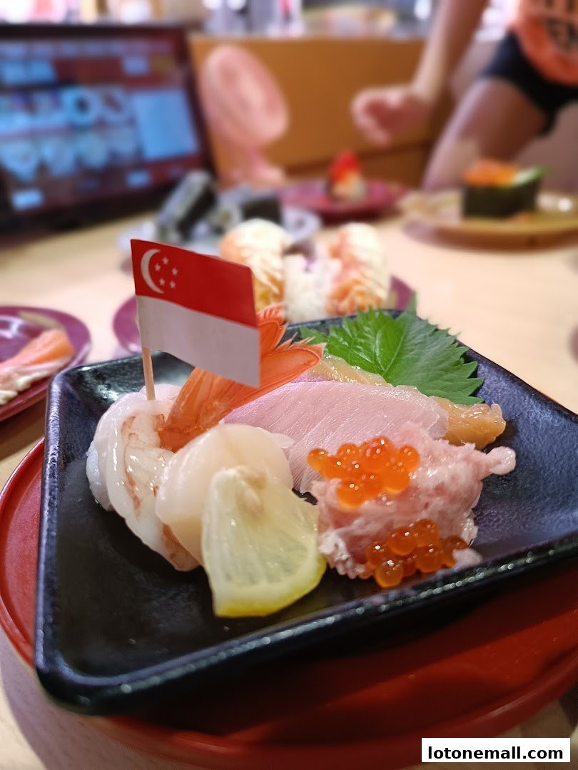 A plate of sashimi with a Singapore flag, served at a sushi restaurant.