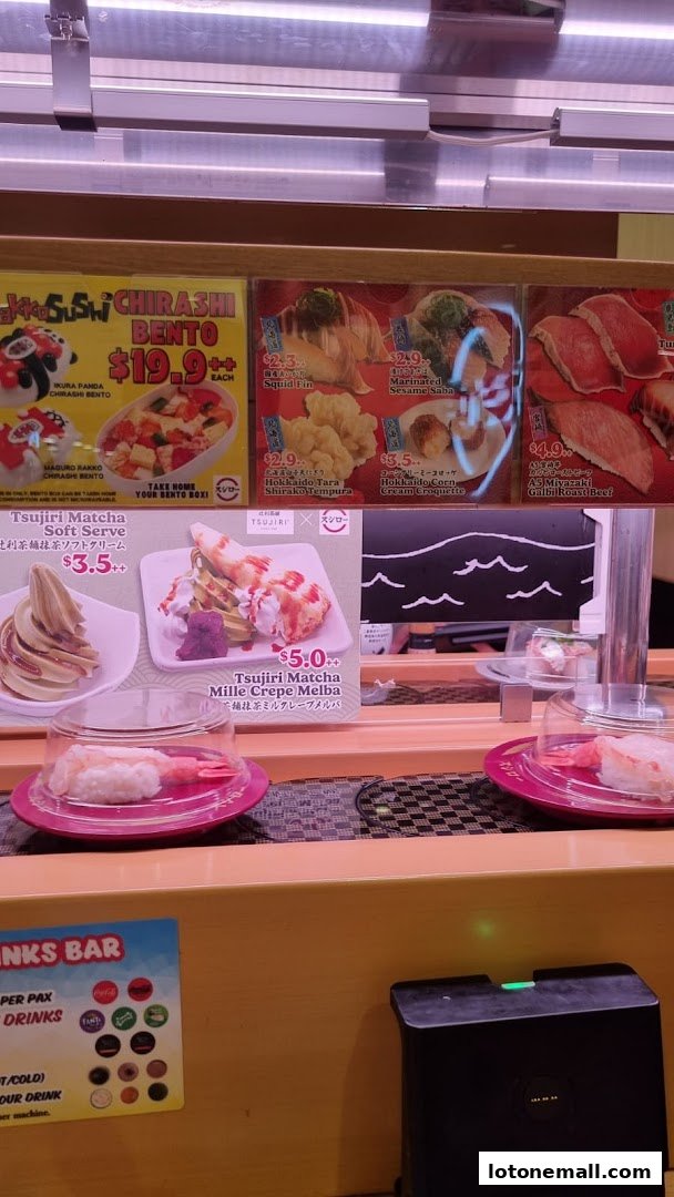 A conveyor belt sushi restaurant display featuring various sushi dishes and desserts.