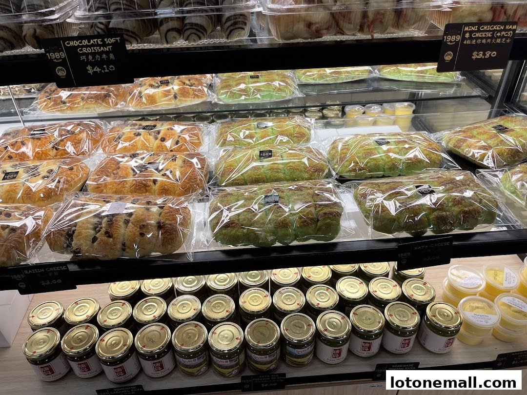 A display case filled with various baked goods and jars of spreads.