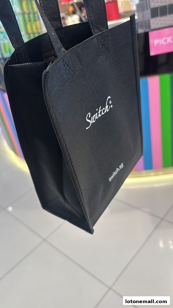 A black reusable shopping bag with the Switch+ logo and website address.
