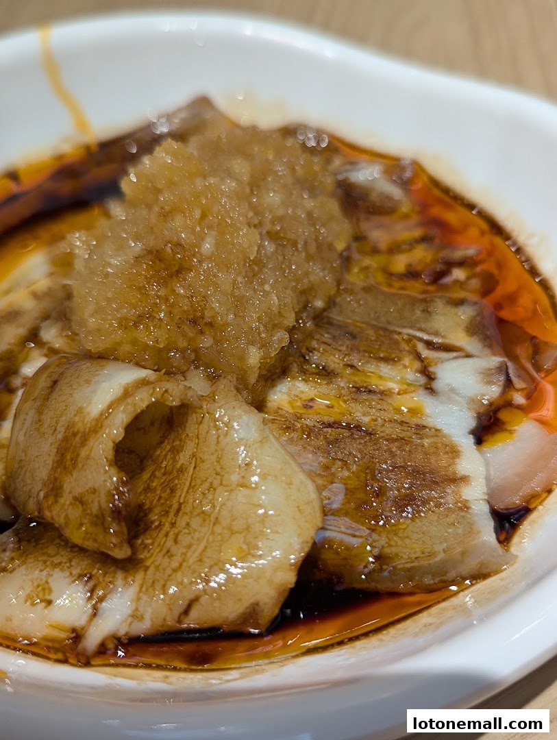 A close-up of a delicious dish with thinly sliced meat and a savory sauce.