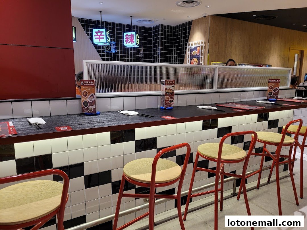 Interior shot of TamJai SamGor Mixian with counter seating and menu displays.