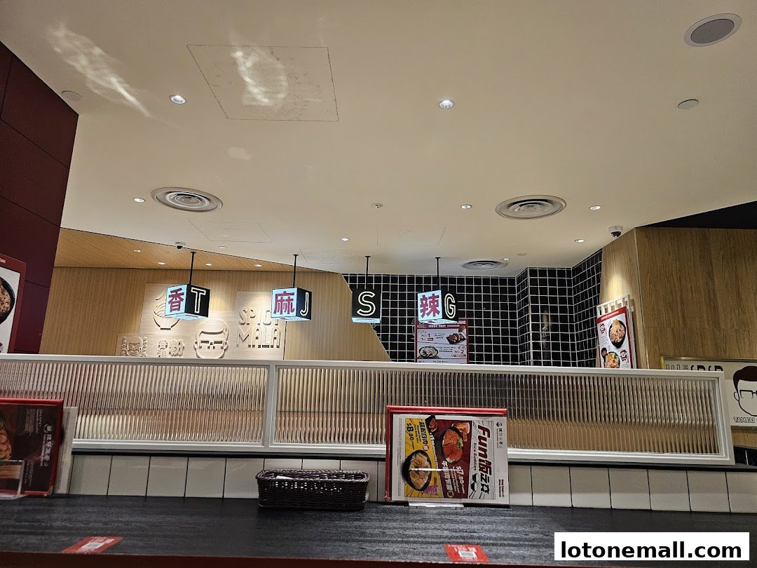 Interior view of TamJai SamGor Mixian restaurant with signage and menu displays.