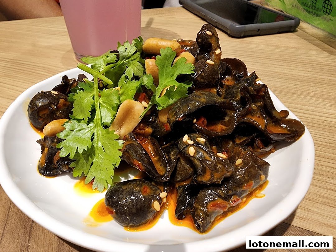 A plate of black fungus salad with peanuts and cilantro, served with a pink drink.