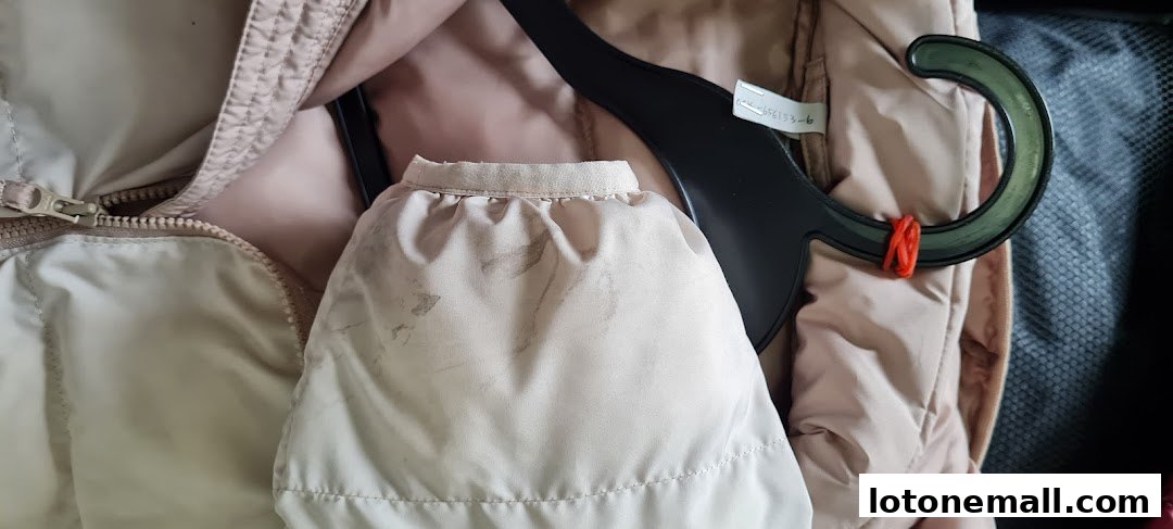Close-up of a stained garment sleeve on a hanger, with a zipper visible.