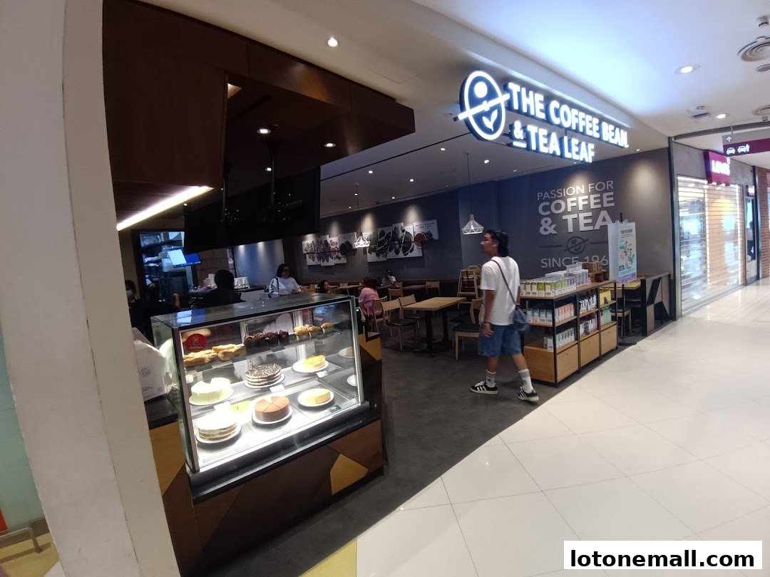 The Coffee Bean & Tea Leaf shop interior with cakes on display and customers seated.