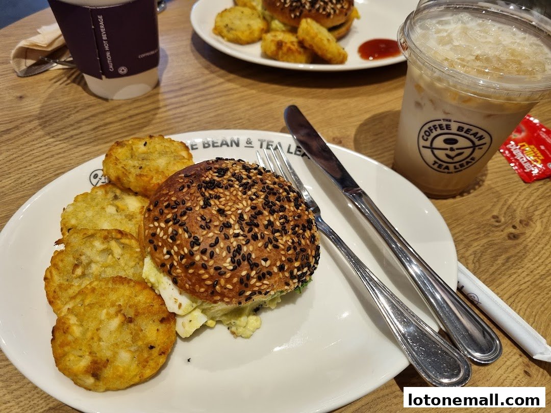A delicious meal from The Coffee Bean & Tea Leaf featuring a burger and hash browns.
