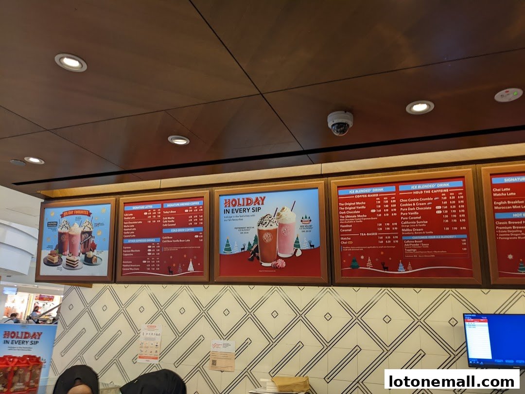 A menu board displaying various coffee and tea beverages with holiday-themed visuals.