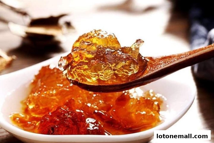 A close-up shot of a wooden spoon holding a glistening, amber-colored jelly dessert.