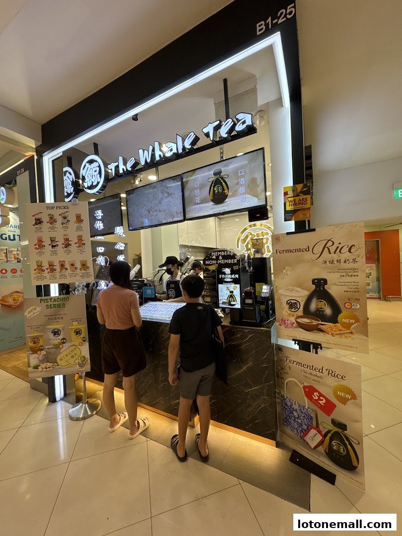 The Whale Tea shop front with customers ordering drinks and promotional posters.