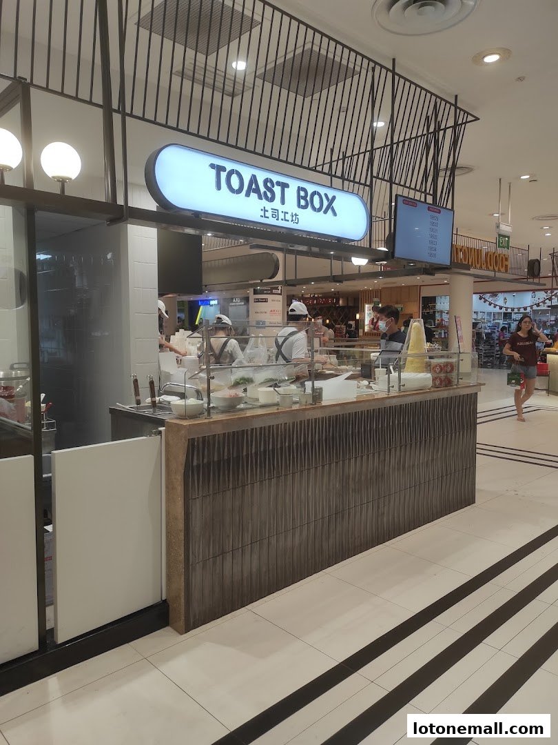 The Toast Box shop front with staff preparing food behind the counter.