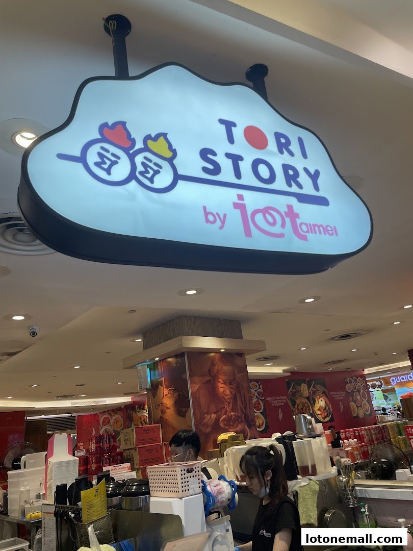 A brightly lit shop interior with a prominent 'Tori Story' sign and staff preparing food.
