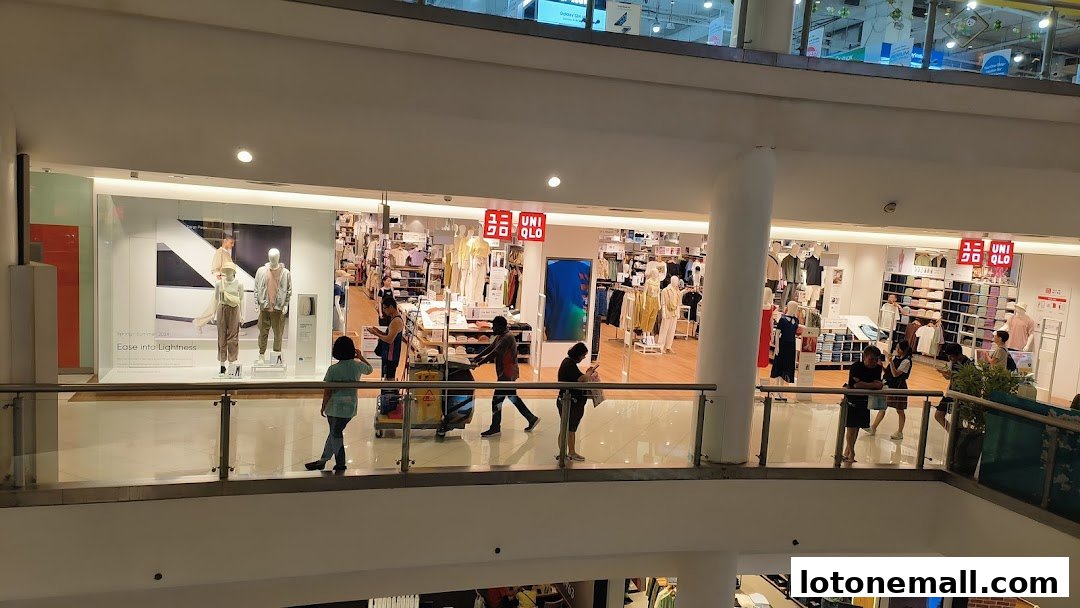 View of the UNIQLO store interior with mannequins and clothing displays, and shoppers.