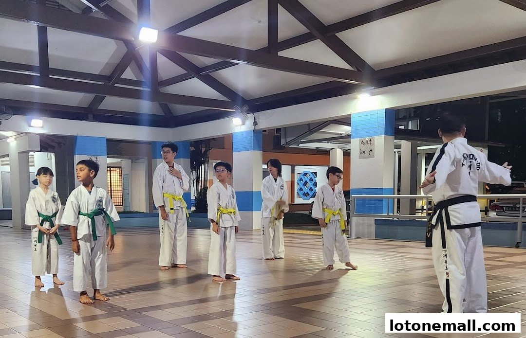 A Taekwondo instructor leads a class of children in a training session.
