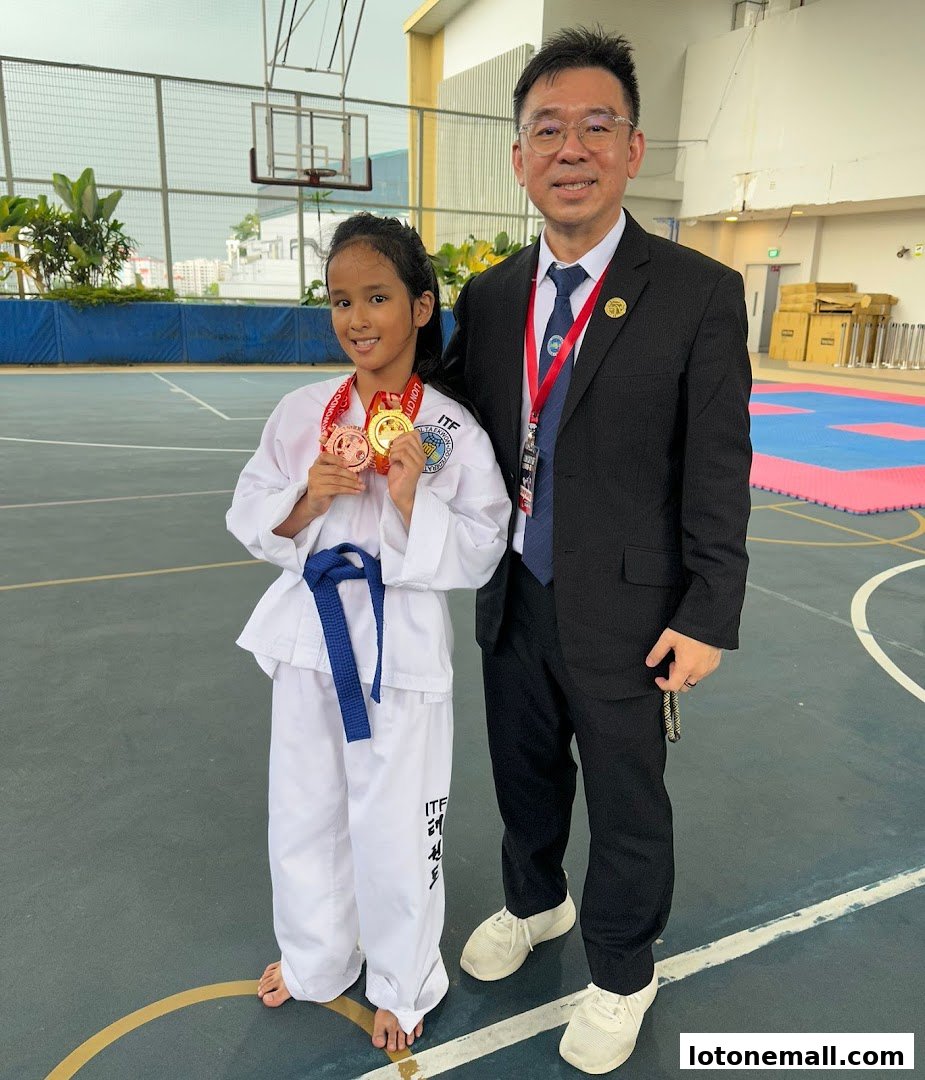 A young girl in a Taekwondo uniform with medals stands next to a man in a suit.