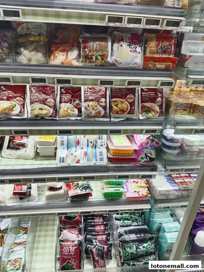 A refrigerated display case filled with various food products, including pastes, frozen items, and dairy.
