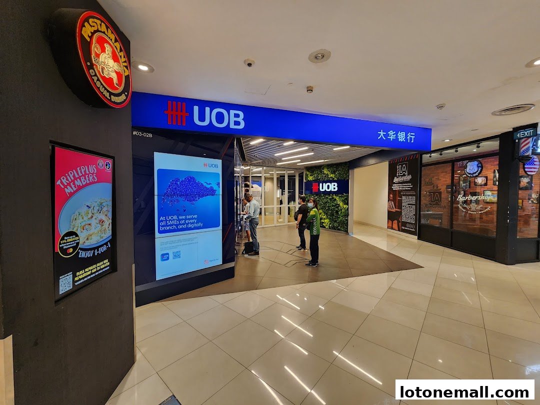 The entrance to a UOB bank branch and adjacent shops in a mall.