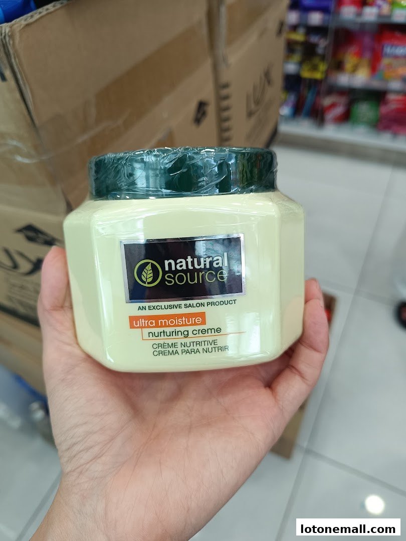 A hand holds a jar of Natural Source ultra moisture nurturing creme.