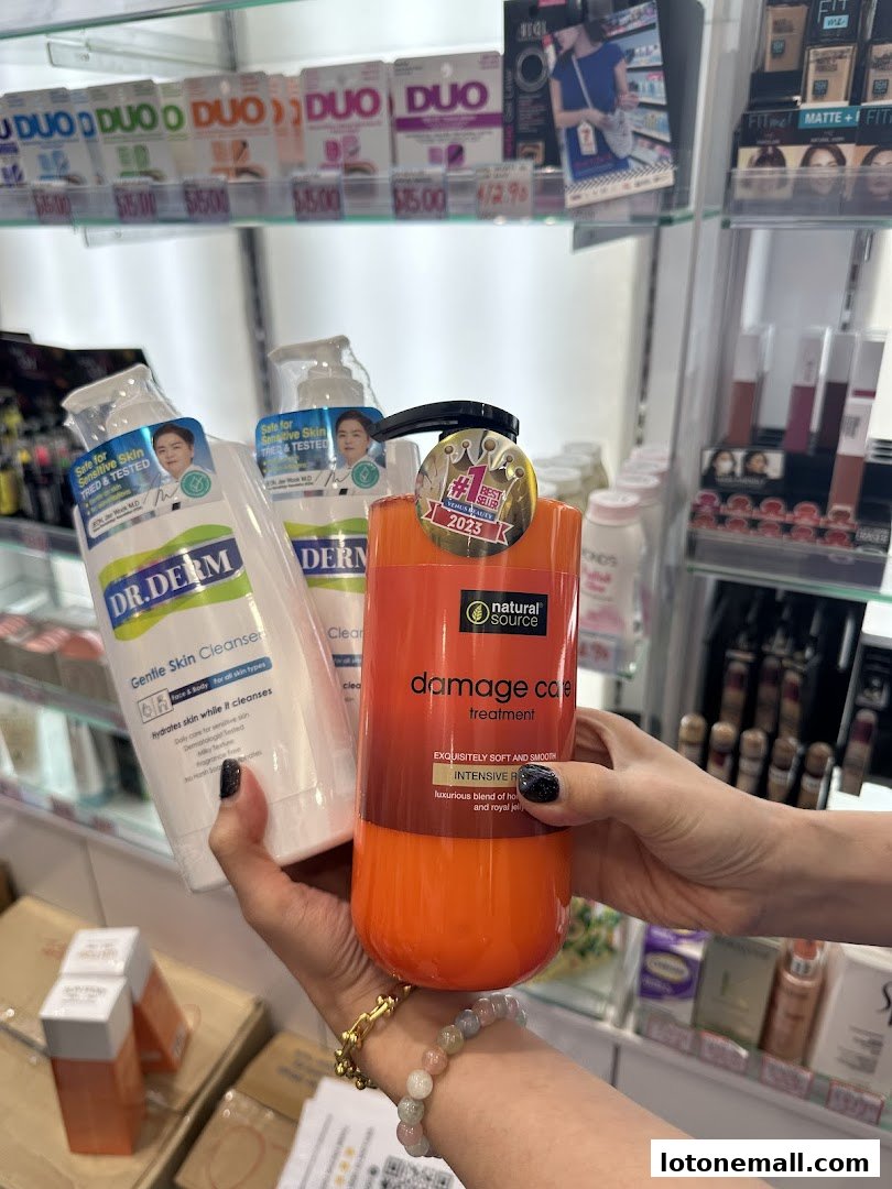 Hands holding skincare products in a beauty store with shelves of cosmetics in the background.